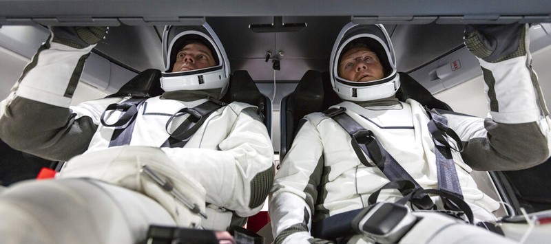 In this Jan. 17, 2020 photo made available by SpaceX, NASA astronauts Bob Behnken, left, and Doug Hurley, wearing SpaceX spacesuits, walk through the Crew Access Arm connecting the launch tower to the SpaceX Crew Dragon spacecraft during a dress rehearsal at NASA's Kennedy Space Center in Cape Canaveral, Fla. For their May 27, 2020 mission, Hurley will be in charge of launch and landing and Behnken will oversee rendezvous and docking at the International Space Station. (SpaceX via AP)