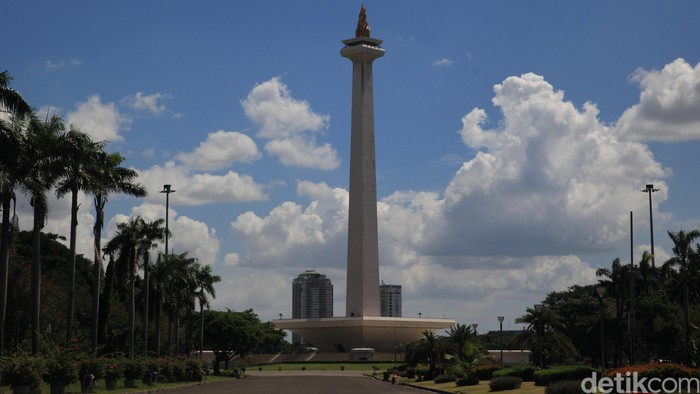 Pengunjung berfoto Dari balik Pagar Monumen Nasional, Jakarta, Senin (25/5/2020). PSBB Corona membuat tempat wisata ditutup untuk umum.