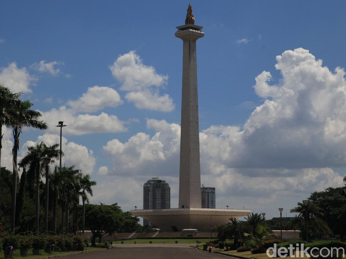 Pengunjung berfoto Dari balik Pagar Monumen Nasional, Jakarta, Senin (25/5/2020). PSBB Corona membuat tempat wisata ditutup untuk umum.