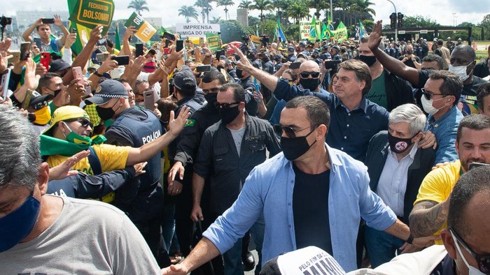 Momen Presiden Brasil Ikut Demo Tanpa Memakai Masker Presiden Brasil Jair Bolsonaro ikut turun ke jalan dan berbicara di hadapan para pendukungnya. Dia menyapa pendukungnya dengan tidak memakai masker.