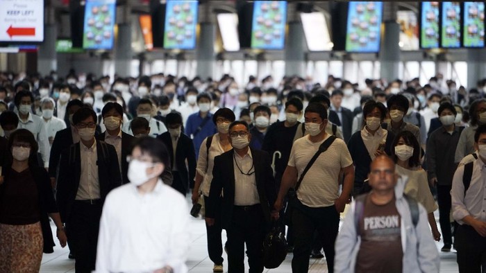 A station passageway is crowded with commuters wearing face mask during a rush hour Tuesday, May 26, 2020, in Tokyo.  Japanese Prime Minister Shinzo Abe lifted a coronavirus state of emergency in Tokyo and four other remaining prefectures on Monday, May 25, ending the declaration that began nearly eight weeks ago.(AP Photo/Eugene Hoshiko)