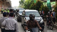Pengendara yang melintas harus memakai masker.
