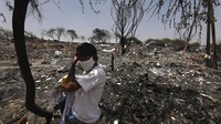 Seorang warga berdiri di area permukiman kumuh yang ludes terbakar di kawasan New Delhi, India, Selasa (26/5/2020).