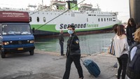 Turis domestik kembali bisa menikmati pelayanan kapal Feri reguler mulai Senin (25/05). Salah satu penumpang memakai masker untuk mencegah penyebaran virus Corona (AP)