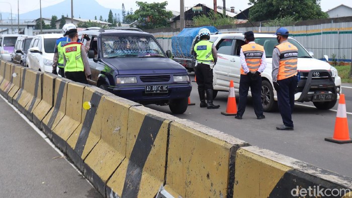 Petugas gabungan yang melakukan penyekatan di Gerbang Tol Cileunyi, Kabupaten Bandung memutar balikan sejumlah kendaraan pemudik yang hendak kembali ke Jakarta.