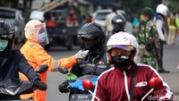 Pengukuran suhu tubuh dilakukan kepada setiap pengendara yang melintas.