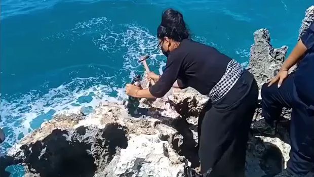 Pemasang melepas patung Nyi Roro Kidul yang terpasang di atas karang Pantai Waterblow Nusa Dua Bali (Screenshot video viral)