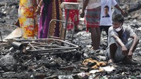 Seorang warga tampak duduk di sisa-sisa bangunan rumahnya yang telah hangus terbakar di kawasan kumuh New Delhi, India.
