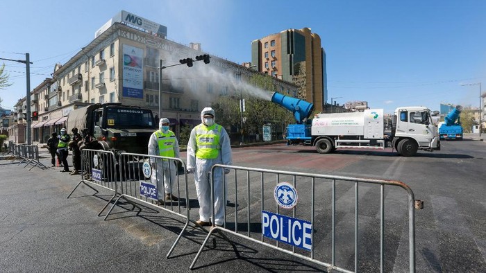 Staff members and police officers wear hazmat suits as they take part in a drill to prepare for the COVID-19 coronavirus in Ulaanbaatar, the capital of Mongolia on May 7, 2020. (Photo by Byambasuren BYAMBA-OCHIR / AFP)