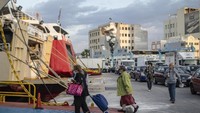 Penumpang bersiap untuk berangkat menaiki kapal feri di pelabuhan Piraeus di dekat Athena. Mereka membawa beberapa bawaan tas dan koper. (Petros Giannakouris/AP)  