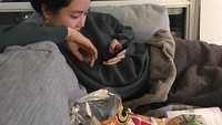 Saat memiliki waktu luang yang cukup banyak, Son Naeun seperti kebanyakan orang yaitu bermain dengan ponselnya dan ngemil beberapa bungkus makanan ringan. Foto: Instagram @marcellasne_