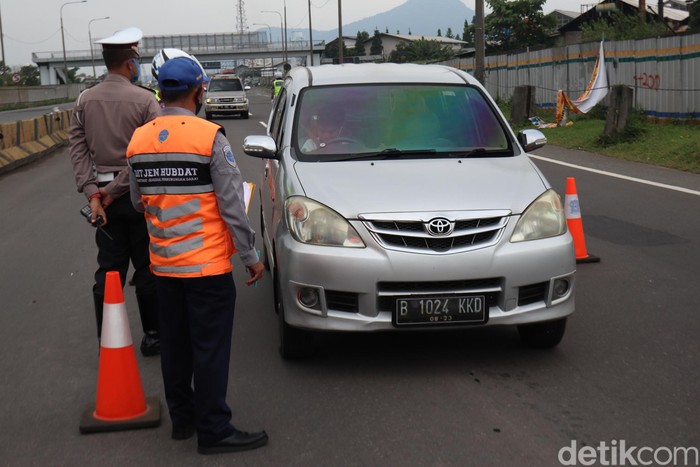 Petugas gabungan yang melakukan penyekatan di Gerbang Tol Cileunyi, Kabupaten Bandung memutar balikan sejumlah kendaraan pemudik yang hendak kembali ke Jakarta.