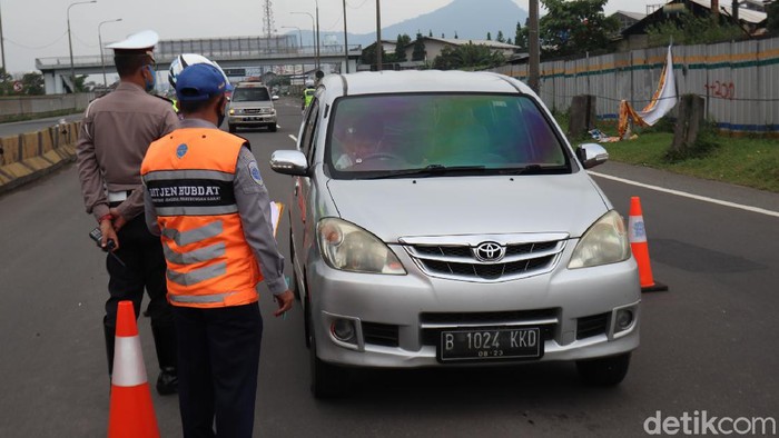 Petugas gabungan yang melakukan penyekatan di Gerbang Tol Cileunyi, Kabupaten Bandung memutar balikan sejumlah kendaraan pemudik yang hendak kembali ke Jakarta.