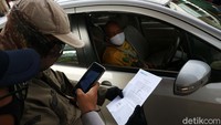 Petugas gabungan memeriksa surat tugas pengendara yang melintas di check point PSBB Kalimalang, Jakarta Timur, Selasa (26/5/2020).