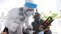 Petugas kesehatan memakai APD untuk melindungi diri dari virus corona selama membantu warga yang mengikuti rapid test.