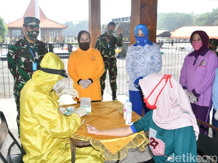 Dengan menerapkan physical distancing, satu per satu warga Surabaya mengikuti rapid test di Kodam V/Brawijaya. Rapid test ini diberikan secara gratis pada 250 warga.