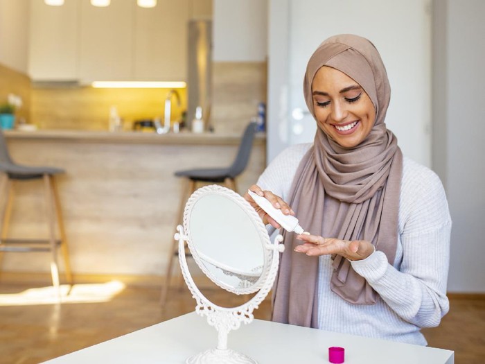 1133860967 Young woman applying face mask at home. Natural Skin Care Routine For Glowing Skin.