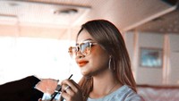Selain ke gerai burger, Aurel Hermansyah juga menikmati minuman segar di sebuah kafe. Sambil memegang gelas minuman, ia berpose candid dan terlihat cantik. Foto: Instagram @aurelie.hermansyah
