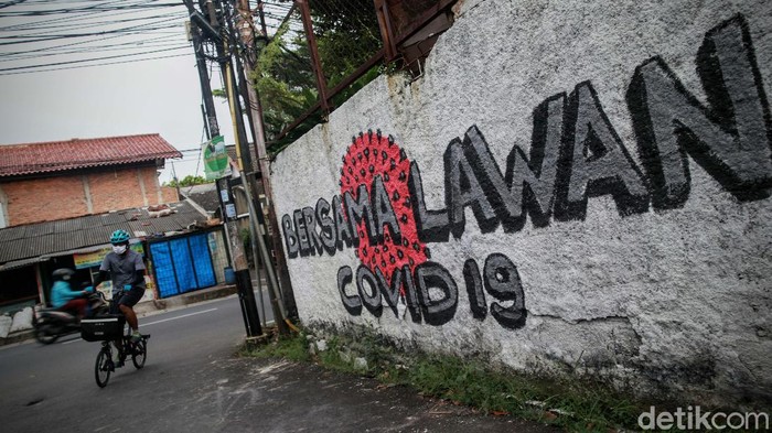 Ini Dia Mural Penyemangat Ayo Lawan Corona Warga melintas di depan mural perlawanan virus Corona, di Bintaro, Jakarta Selatan, Rabu (27/5). Mural ini mengajak warag hidup sehat untuk melawan virus Corona.