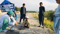 Idress Seyawash (kiri) seorang dermawan yang membawa perpustakaan keliling terlihat emngajak sejumlah anak untuk mencuci tangan dengan sabun di kawasan Afghanistan. Sejak awal pandemi COVID-19, UNICEF telah memasok lebih dari 84 ton sabun kepada keluarga-keluarga yang paling rentan di Afghanistan.