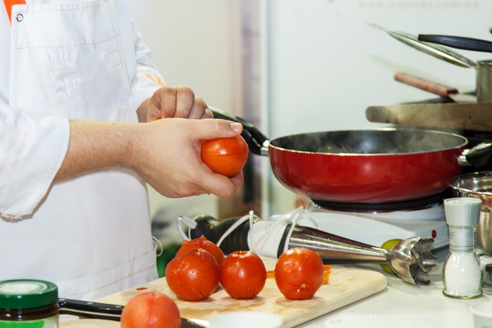 Chef prepares tomatoes for vegetarian meals