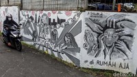 Warga melintas di depan mural perlawanan virus Corona, di Bintaro, Jakarta Selatan, Rabu (27/5/2020).