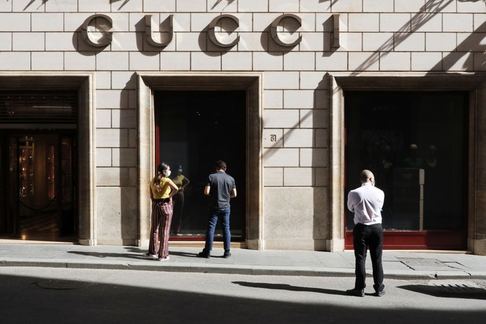 ROME, ITALY - MAY 15: Two Gucci employees decide how to separate the entrance and exit of customers in view of the reopening of the store on May 15, 2020 in Rome, Italy. Italy was the first country to impose a nationwide lockdown to stem the transmission of the Coronavirus (Covid-19) and it has started to ease these restrictions in recent weeks. The initial reopening date decided by the government would have been June 1, but due to pressure from the regional governments, trade associations and the public, this process has been accelerated. However, many businesses have complained that the government has not provided complete safety guidelines for the various types of businesses permitted to reopen and, consequently, some have decided to postpone their opening. (Photo by Marco Di Lauro/Getty Images)
