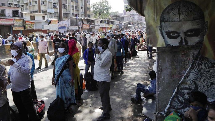 Migrant workers and their families gather for transport to the railway station for their onward journey to their home states, at Dharavi slum in Mumbai, India, Tuesday, May 26, 2020. Indias lockdown was imposed on March 25 and has been extended several times. On May 4, India eased lockdown rules and allowed migrant workers to travel back to their homes, a decision that has resulted in millions of people being on the move for the last two weeks. (AP Photo/Rajanish Kakade)