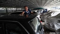 Seorang pekerja sedang membersihkan mobil-mobil yang berada di Kantor Pegadaian, Jakarta Timur, Rabu (27/5/2020).
