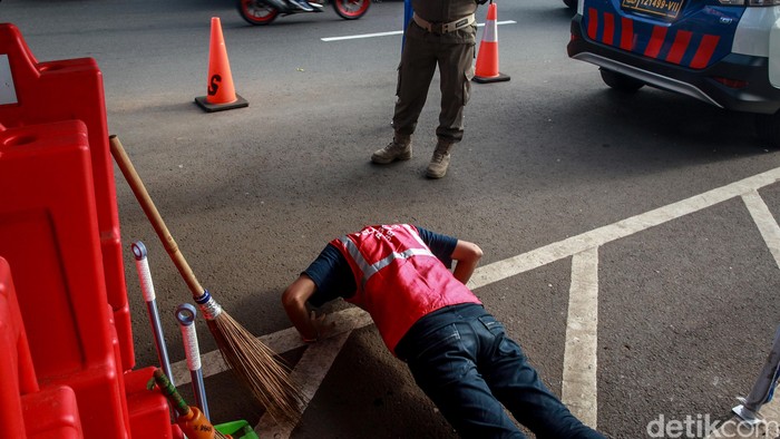 Para pelanggar dihukum push-up atau menyapu jalanan di check point PSBB Lebak Bulus, Rabu (27/5/2020). Meski sudah lebih dari sebulan penerapan Pembatasan Sosial Berskala Besar (PSBB), masih saja ada yang bandel dengan tidak mengindahkan aturan menggunakan masker.