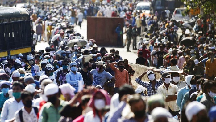 Migrant workers and their families gather for transport to the railway station for their onward journey to their home states, at Dharavi slum in Mumbai, India, Tuesday, May 26, 2020. Indias lockdown was imposed on March 25 and has been extended several times. On May 4, India eased lockdown rules and allowed migrant workers to travel back to their homes, a decision that has resulted in millions of people being on the move for the last two weeks. (AP Photo/Rajanish Kakade)
