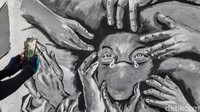 Sejumlah warga tampak mengabadikan mural tersebut.