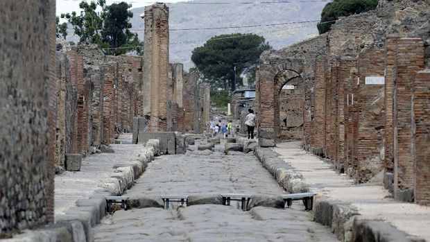 People take photos as they visit the archeological site of Pompeii, Italy, as the site reopened to the public after a two-month lockdown due to the COVID-19 pandemic, Tuesday, May 26, 2020. (AP Photo/Alessandra Tarantino)