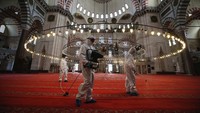 Para pekerja menyemprotkan disinfektan di Masjid Suleymaniye yang bersejarah di Istanbul, Turki.