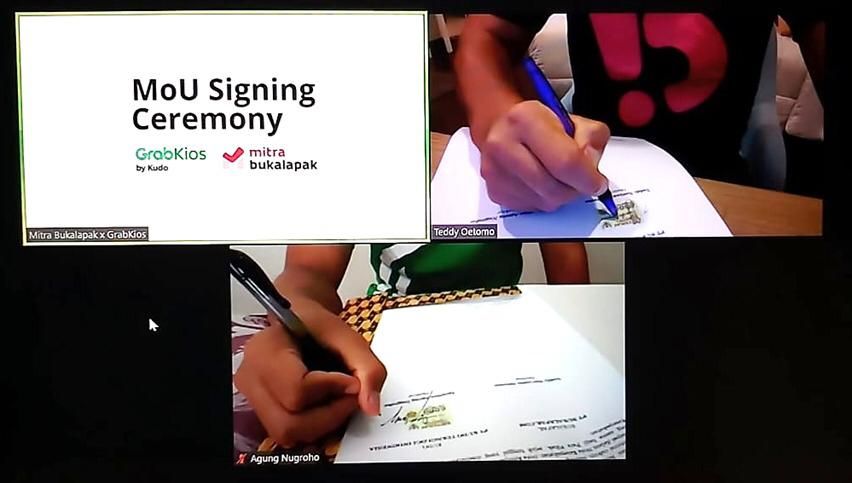 Penandatanganan nota kesepahaman (MoU) antara Mitra Bukalapak dengan GrabKios (28/5) sebagai awal kerjasama strategis dalam penyediaan dan penyaluran akses produk digital oleh GrabKios di hampir 5 juta warung serta agen Mitra Bukalapak. Penandatanganan ini dilaksanakan secara virtual simbolis untuk mendukung kebijakan pemerintah dalam melakukan Pembatasan Sosial Berskala Besar (PSBB). (Dok. Grab)