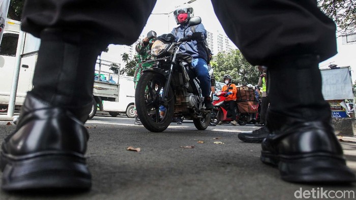 Petugas gabungan melakukan pengecekan terhadap warga dengan plat nomor luar Jakarta di Daan Mogot, Jakbar, Kamis (28/5). Pengecekan ini guna mencegah arus balik.
