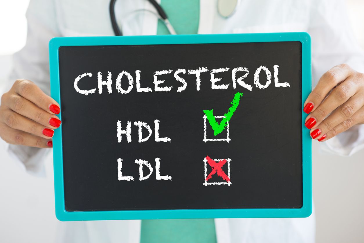 Good HDL and bad LDL cholesterol written on blackboard by unrecognizable doctor with stethoscope