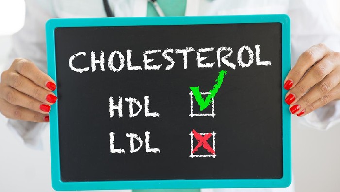 Good HDL and bad LDL cholesterol written on blackboard by unrecognizable doctor with stethoscope