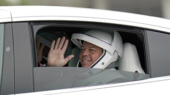 Astronaut NASA Bob Behnken melambaikan tangan saat kembali dari landasan peluncuran. Foto: AP/David J. Phillip