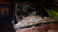 Banyak sisa batu bata dan batu yang masih berserakan di bagian kap mobil dan kabin sopir.