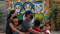 Warga melintas di depan mural bertema ungkapan terimakasih untuk tim medis COVID-19.