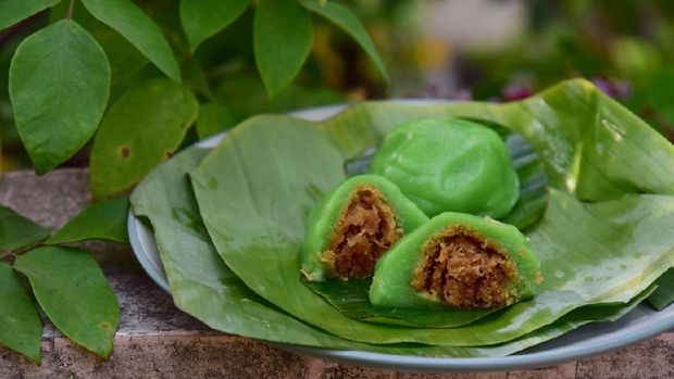 Kue bugis hijau Kue Bugis, Indonesian jajan pasar, traditional snack of glutinous rice flour cake filled with sweet grated coconut, underlined with banana leaf. Popular snack during Ramadan as Takjil