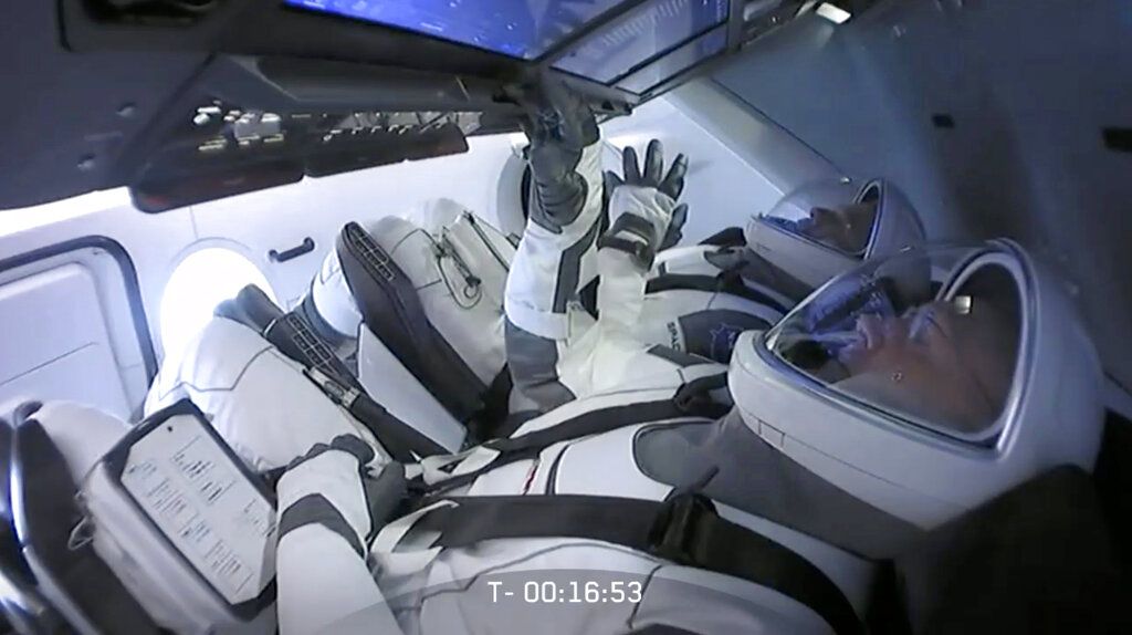 In this Wednesday, May 27, 2020 image from video made available by SpaceX, NASA astronauts Bob Behnken, background left, and Doug Hurley sit in the Crew Dragon capsule as the launch from the Kennedy Space Center in Cape Canaveral, Fla., is aborted due to weather problems. (SpaceX via AP)