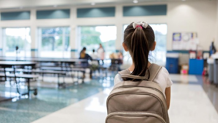 Ilustrasi anak mulai masuk sekolah Elementary schoolgirl enters the school cafeteria. She pauses while looking for a friend.