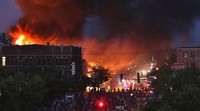 Sebuah bangunan dibakar massa saat demo yang berujung rusuh di Minneapolis, Kamis (28/5) waktu setempat.