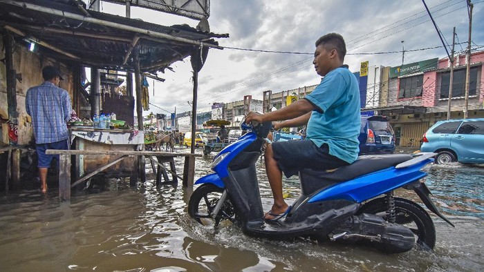 BANJIR AKIBAT DRAINASE BURUK DI MATARAM Seorang perempuan berjalan melintasi genangan air di jalan Pasar Kebon Roek, Ampenan, Mataram, NTB, Jumat (29/5/2020). Banjir tersebut diakibatkan oleh buruknya drainase dan tingginya intensitas hujan yang terjadi di wilayah Ampenan dan sekitarnya. ANTARA FOTO/Ahmad Subaidi/pras.