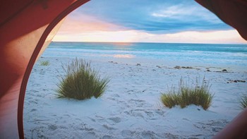 Berkemah di pinggir pantai? Kenapa tidak? Foto: Unsplash / Roxanne Desgagnés via PopSugar