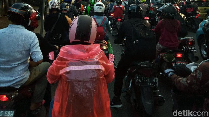 Warga berusaha melindungi dirinya agar tidak terpapar virus Corona. Pemotor ini bahkan rela memakai jas hujan sebagai APD untuk mencegah Corona.