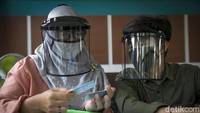 Meski menggunakan face shield, para petugas tetap melakukan pelayanan dengan maksimal.