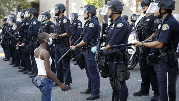 A masked protester kneels before San Jose police on Friday, May 29, 2020, in San Jose, Calif., in response to the death of George Floyd in police custody on Memorial Day in Minneapolis. (AP Photo/Ben Margot)